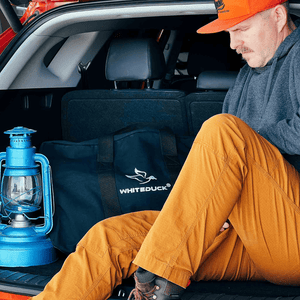 White Duck Outdoors Hoplite Canvas Parachute Bag black in car with a man