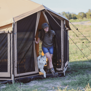 White Duck Outdoors Altimus Bell Tent in grasslands with woman with her dog coming out