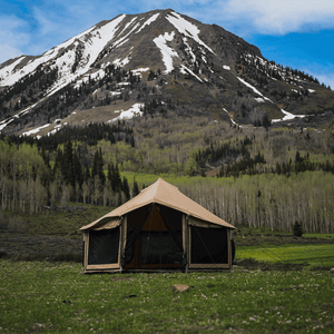 White Duck Outdoors Altimus Bell Tent set outdoors in front of mountain