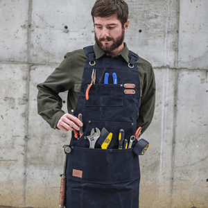White Duck Outdoors Black Work Apron with man getting pliers from pocket