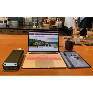 Photo of Bluetti - AC10 99Wh/26756mAh Portable Power Station hooked in a laptop and a tablet on a table.