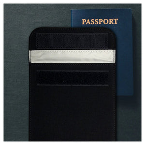 Picture of a Cell phone black canvas X-large privacy protection 4.5 x 6.5 Bag beside a passport.