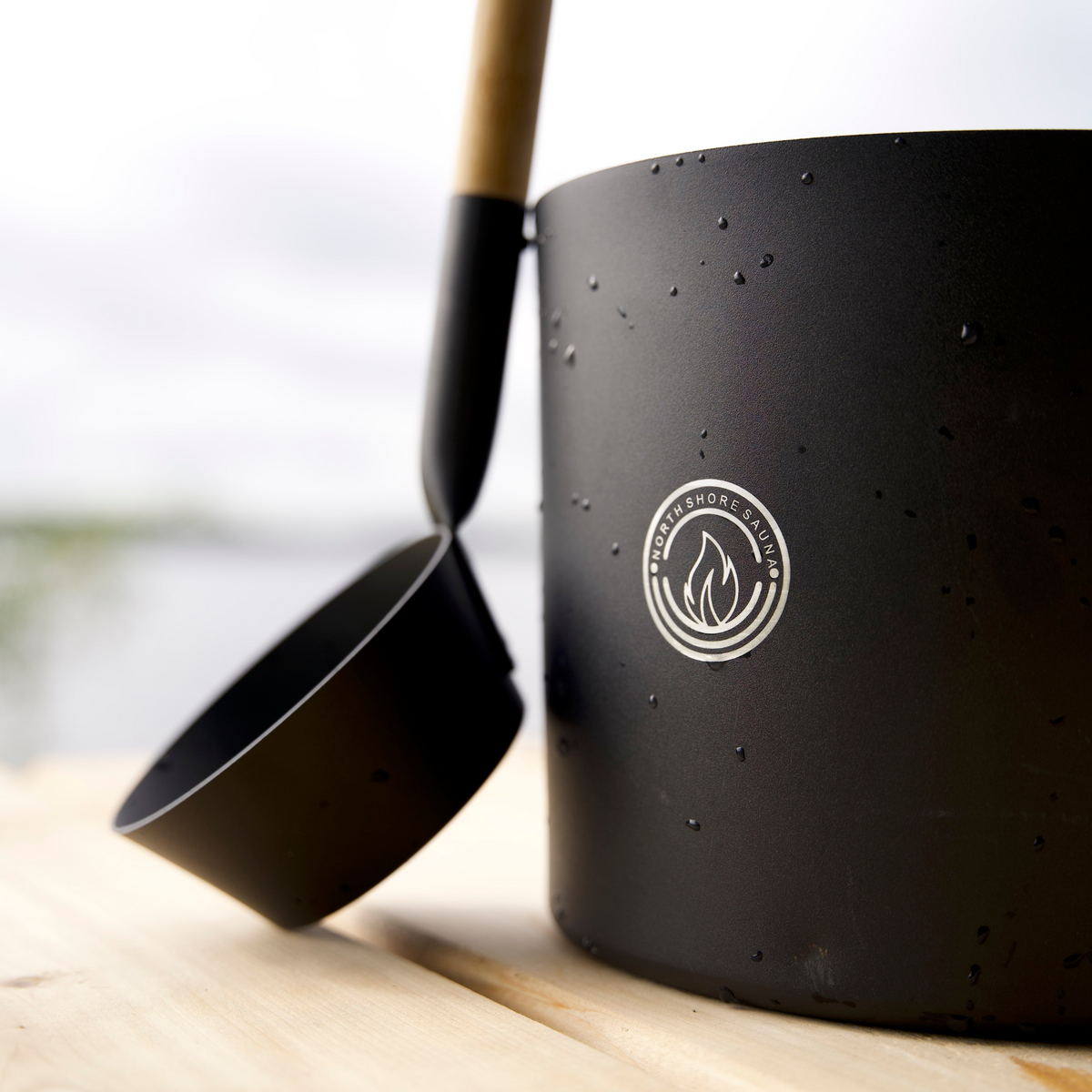Picture of 5L Black Aluminum Sauna Bucket and Ladle Set with Elegant Bamboo Handle leaning on bucket