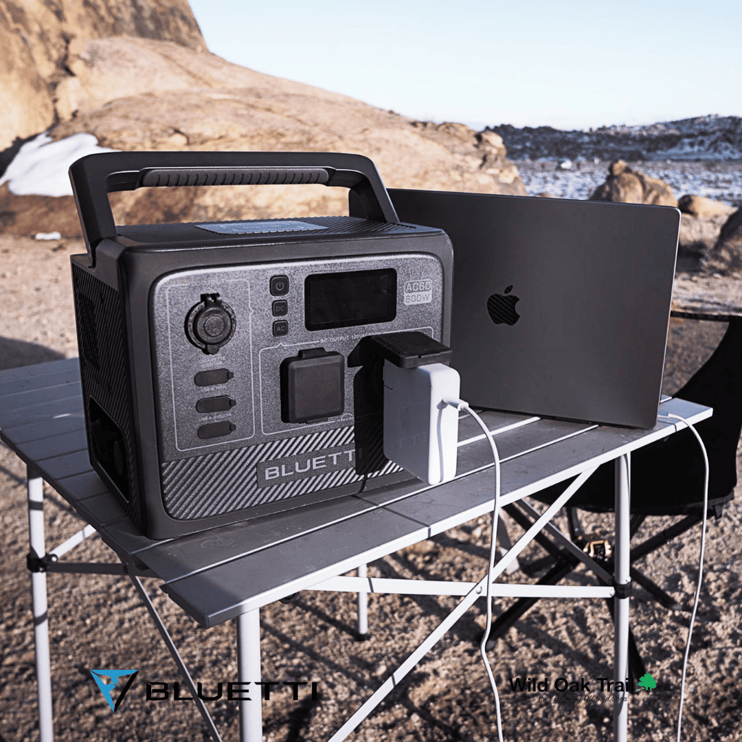 Bluetti AC60 charging laptop on a beach