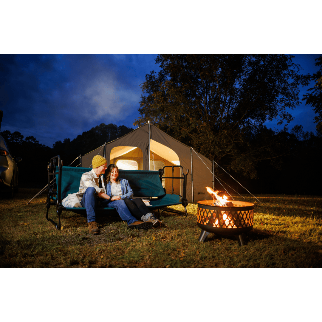 Extra Large Disc-O-Bed Portable Cot System benched outdoors with couple sitting