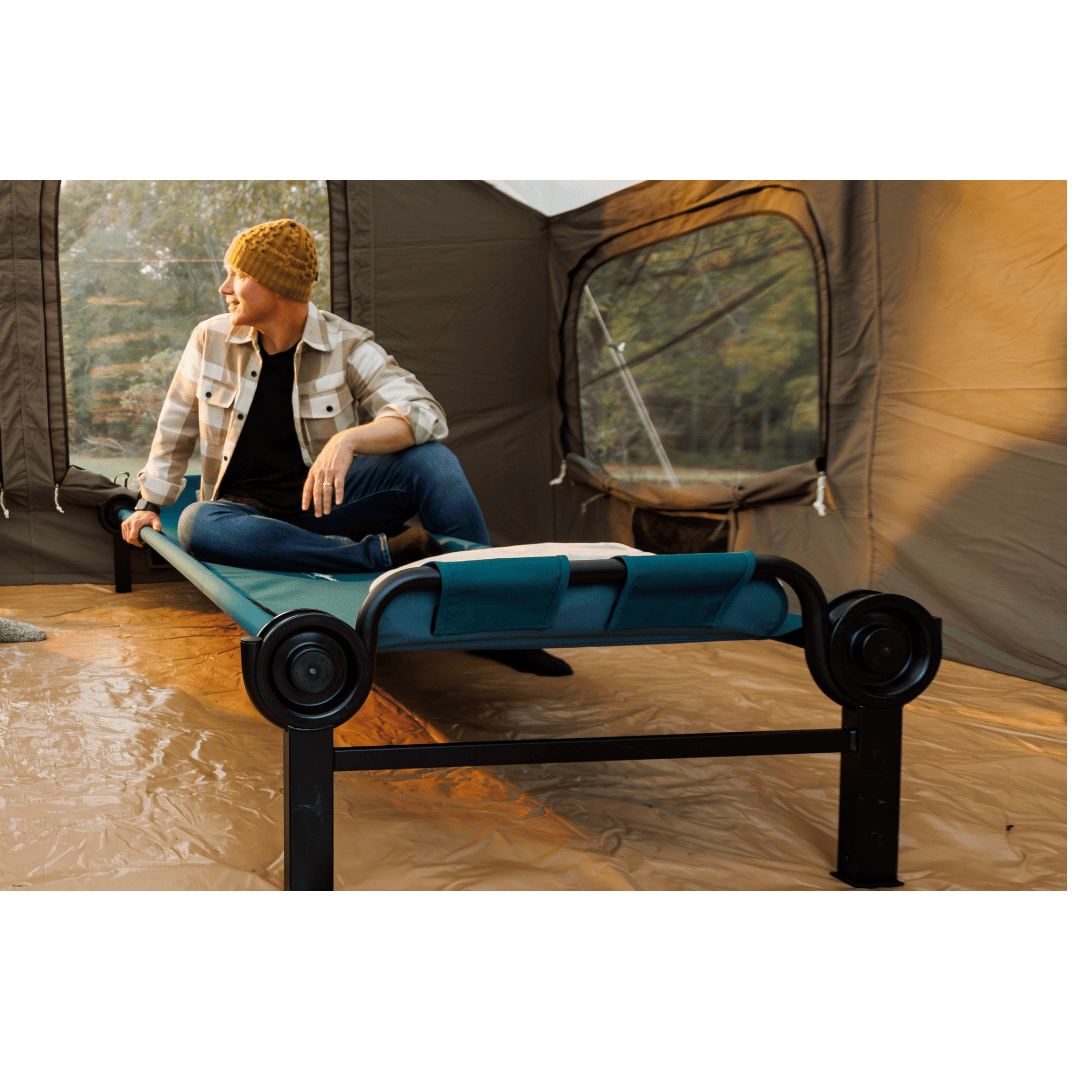 Large Disc-O-Bed Single Camping Cot with man sitting on top