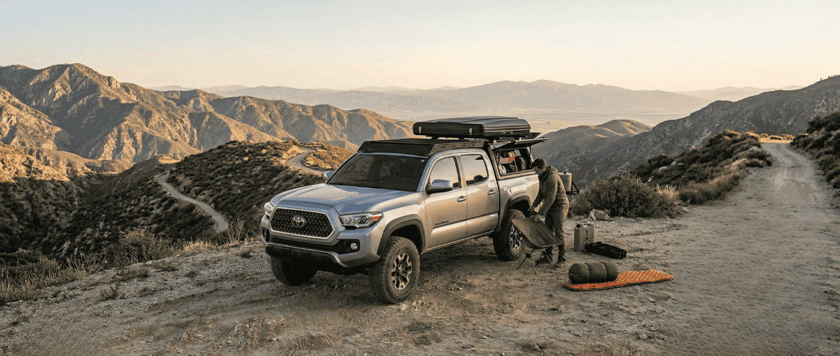 Overland Vehicle Systems Expedition Truck Cap for 2016 to 2023 Toyota Tacoma set up on mountain trail