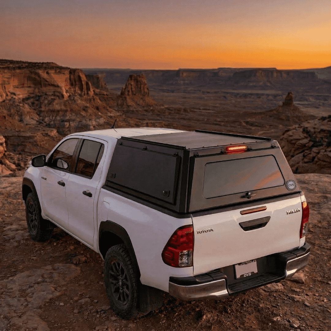 Overland Vehicle Systems Expedition Truck Cap for 2016 to 2026 Toyota Hilux - 5 ft. Bed parked with opened windows