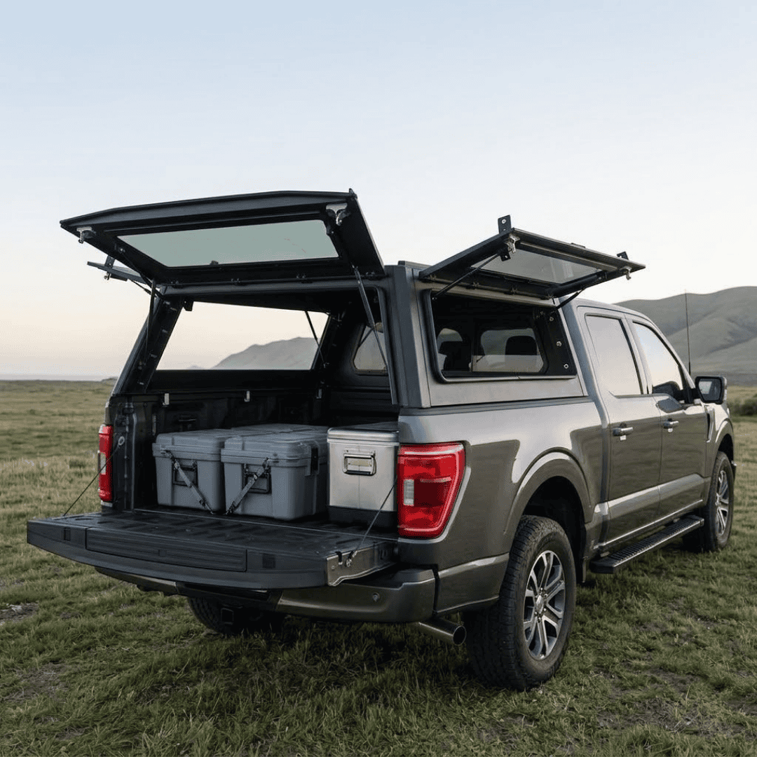 Overland Vehicle Systems Expedition Truck Cap for 2021 to 2026 Ford F-150 6.5 ft. Bed parked with panels opened
