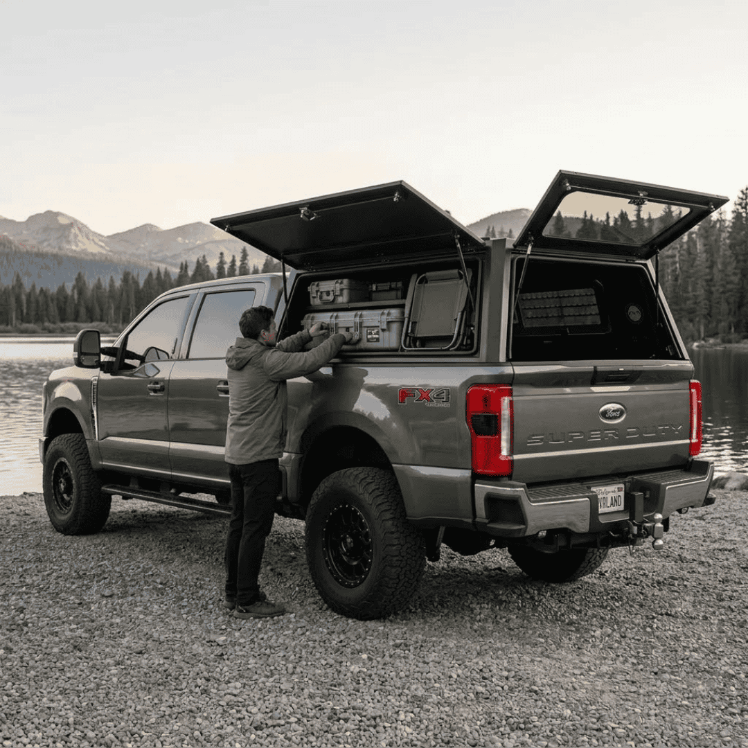 Overland Vehicle Systems Expedition Truck Cap for 2023 to 2026 Ford F-250/F-350 6.8 ft. Bed parked with panels opened