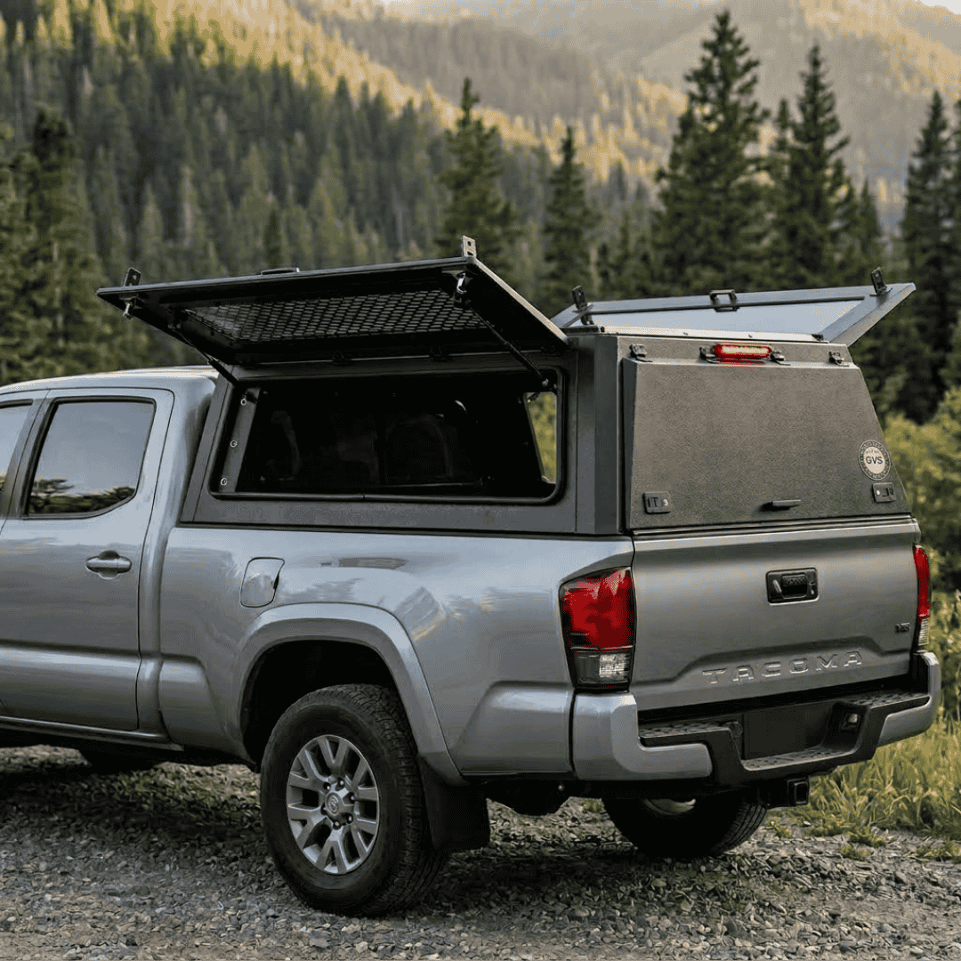 Overland Vehicle Systems Expedition Truck Cap with Sliding Windows for 2016 to 2023 Toyota Tacoma 6 Ft. Bed parked with opened windows