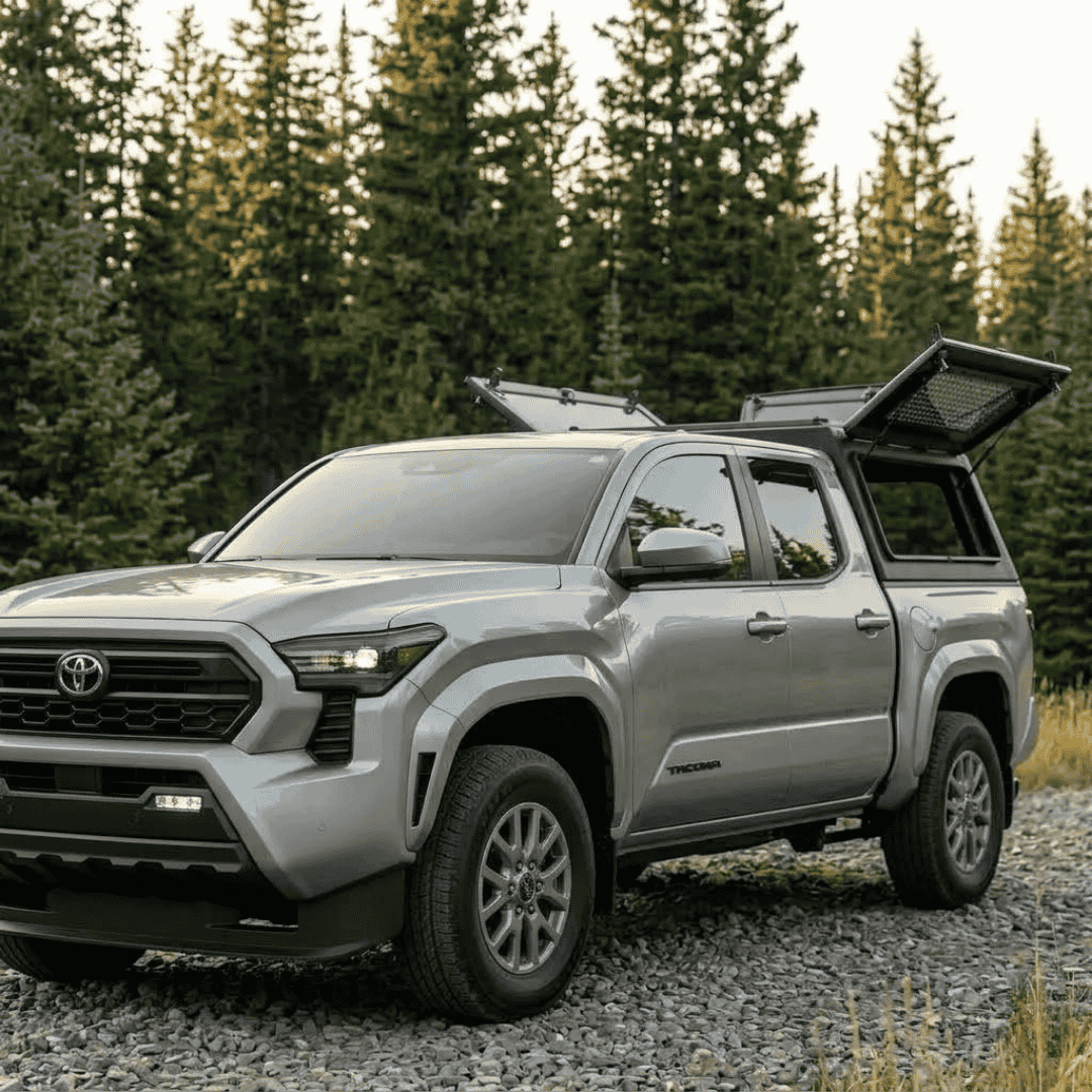 Overland Vehicle Systems Expedition Truck Cap with Sliding Windows for 2024 to 2026 Toyota Tacoma - 5 Ft. Bed parked with opened windows