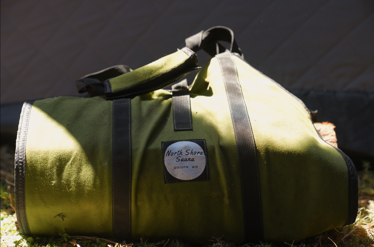 North Shore Sauna Firewood Carrying Bag  laying on grass