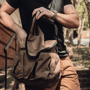 White Duck Outdoors Filios Messenger Bag with man opening flap