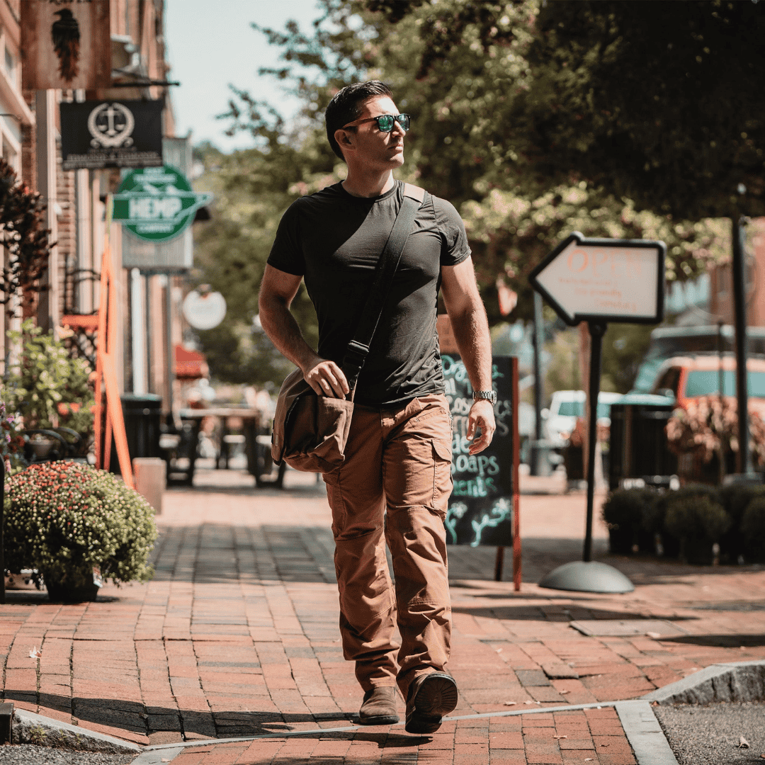 White Duck Outdoors Filios Messenger Bag with man walking down the street