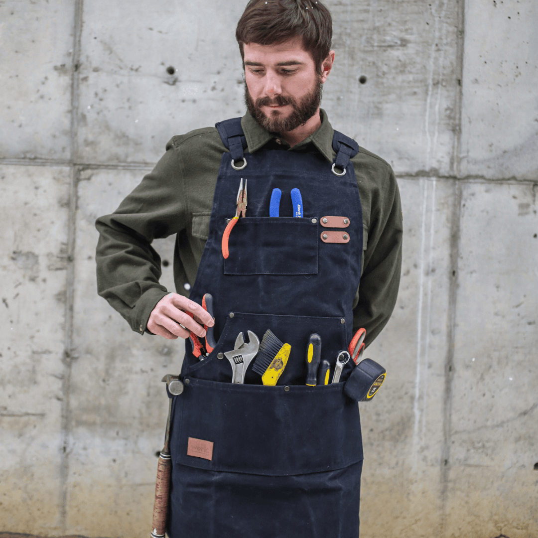 White Duck Outdoors Black Work Apron with man getting pliers from pocket