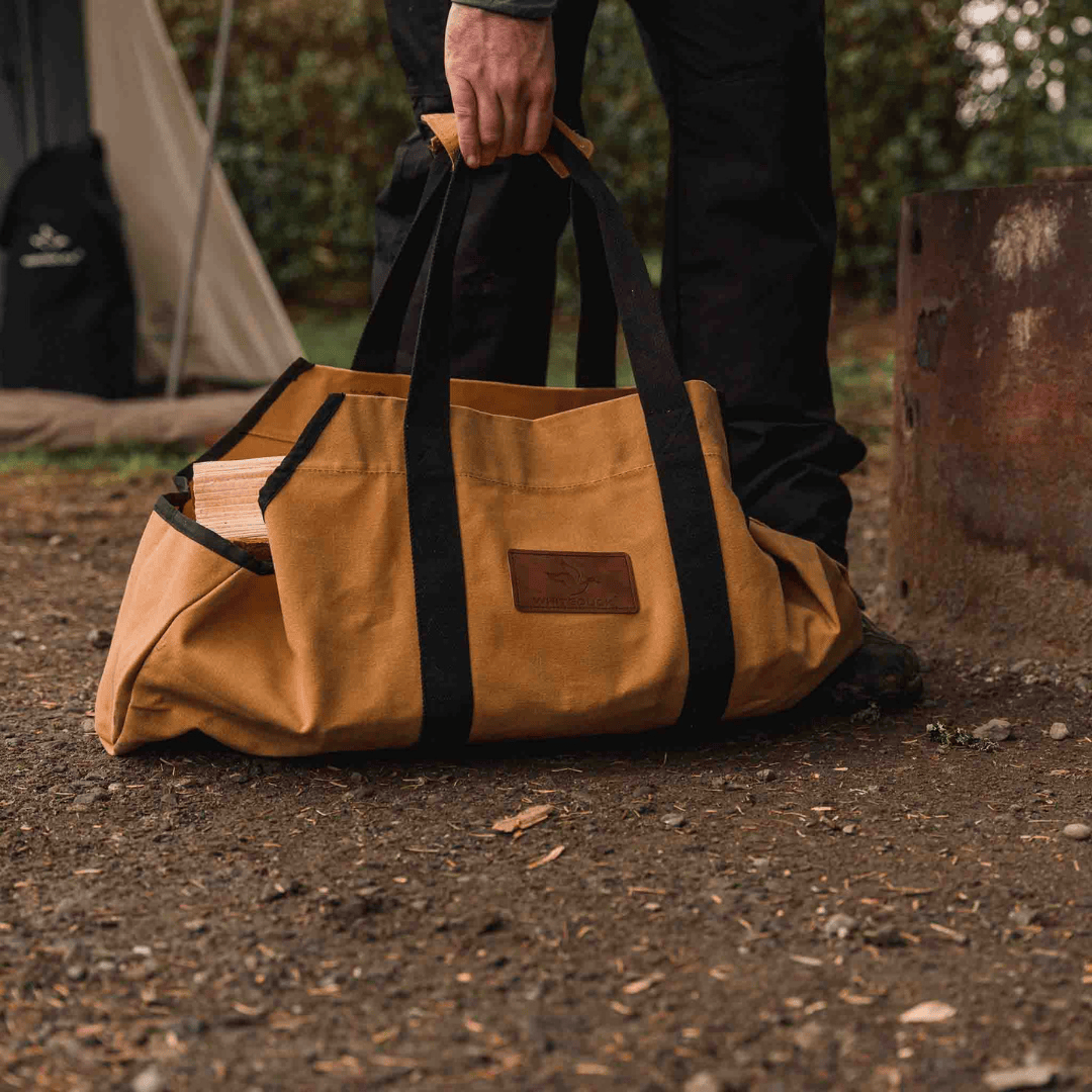 White Duck Outdoors Boat Canvas Log Carrier Bag tan with logs on dirt ground