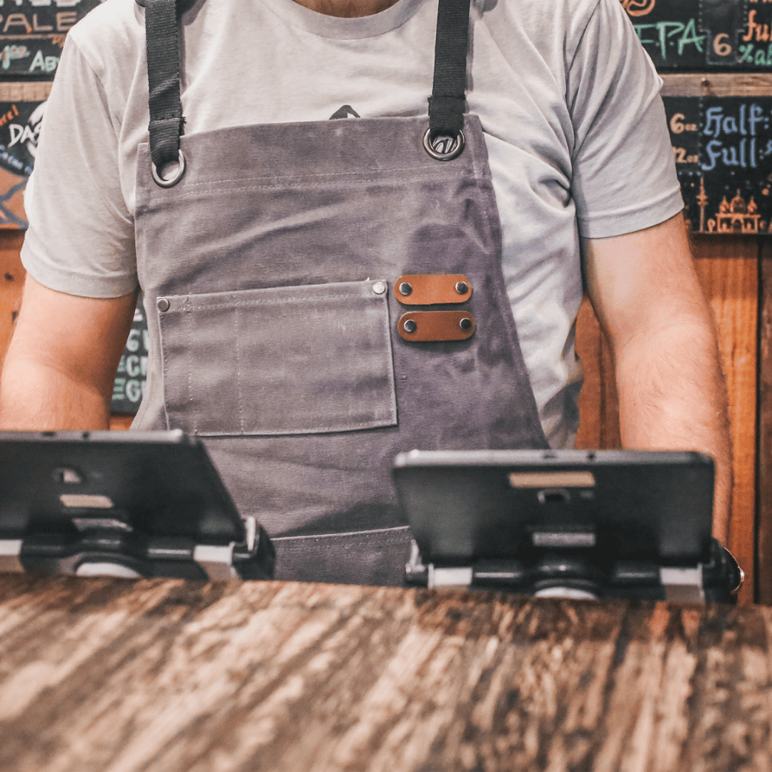 White Duck Outdoors Charcoal Work Apron with man handling tablets