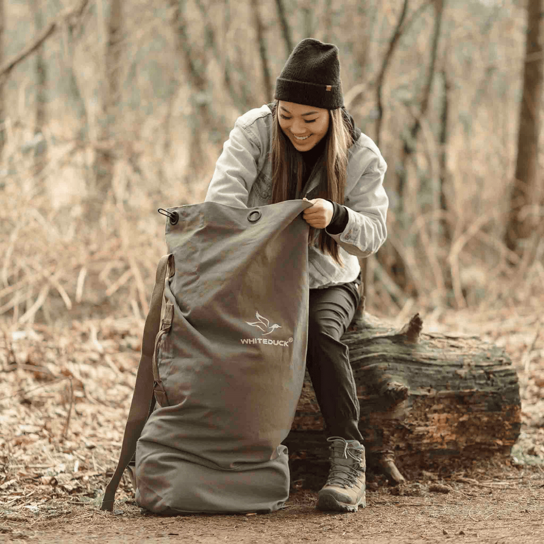 White Duck Outdoors Hoplite Canvas Top Load Bag being used by a girl