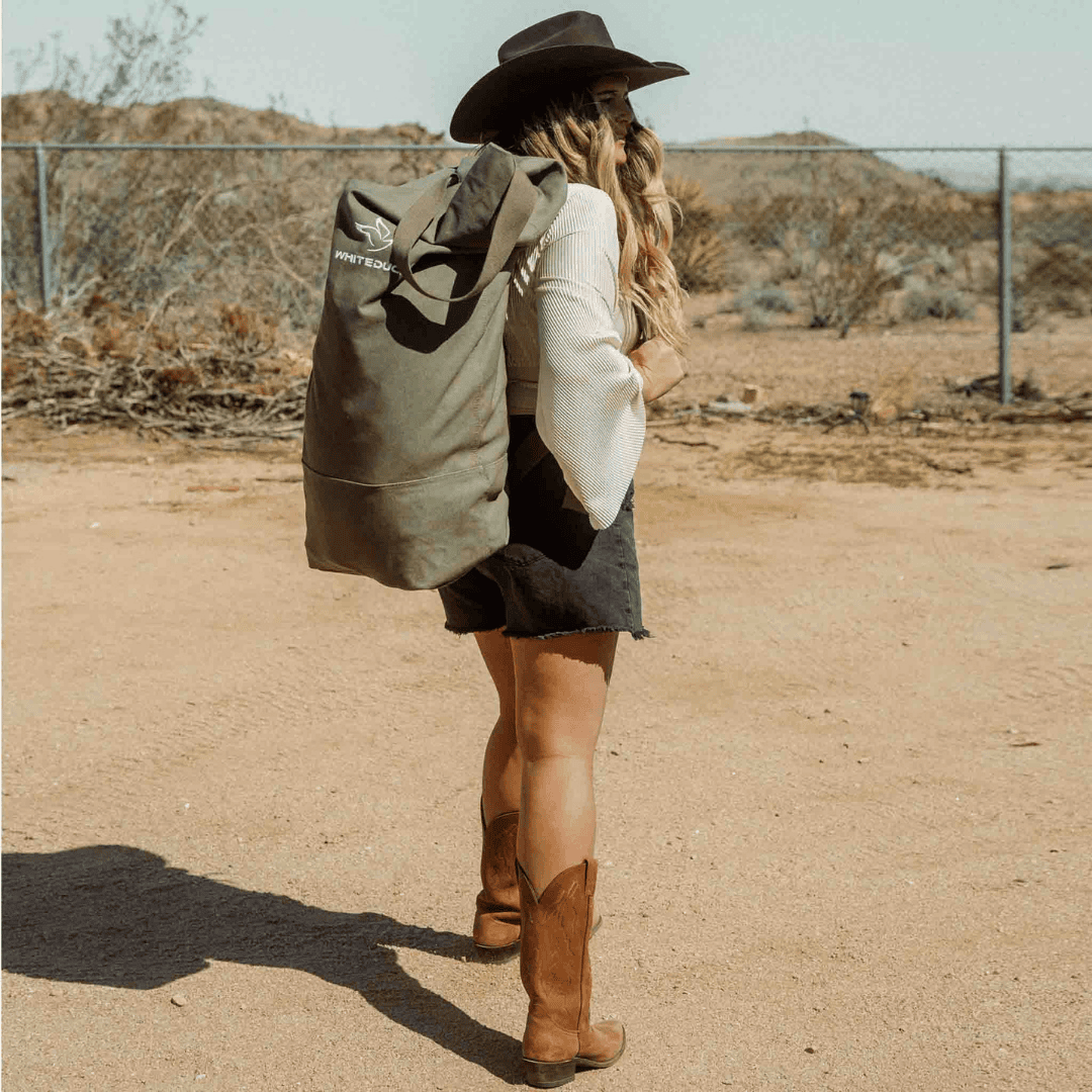 White Duck Outdoors Hoplite GI Canvas Top Load Bag worn by woman