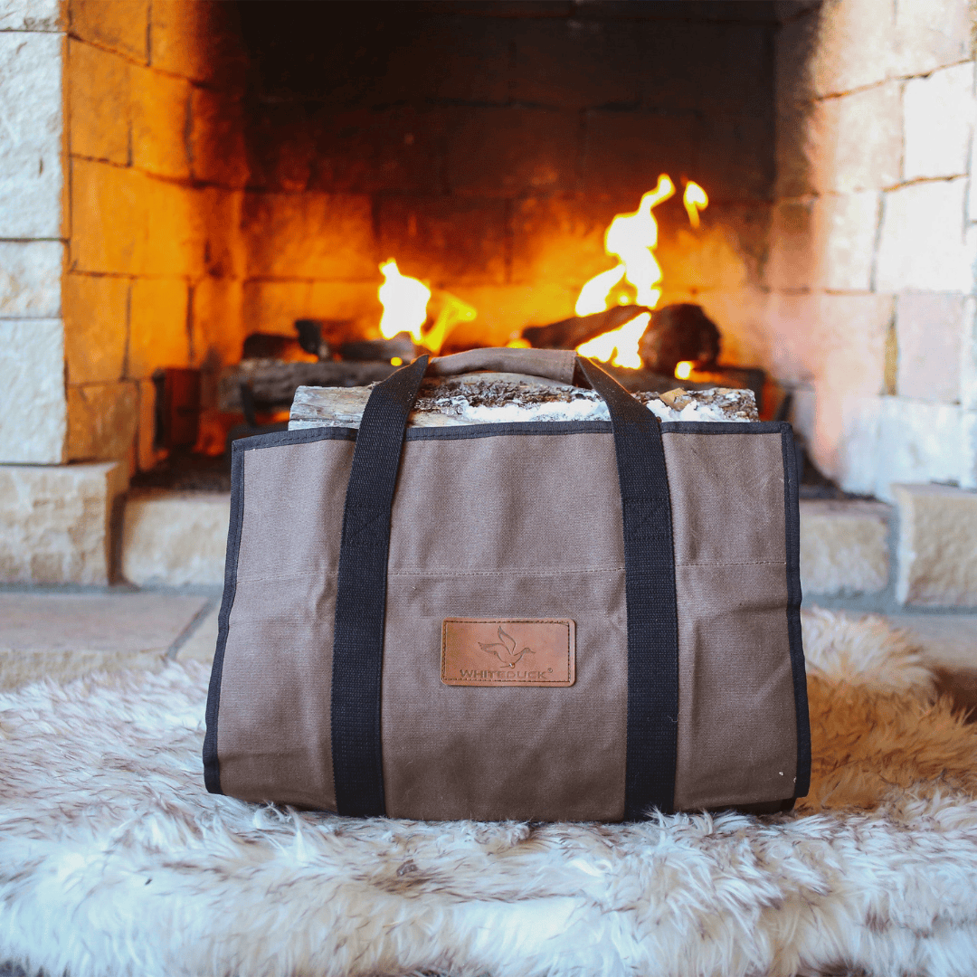 White Duck Outdoors Rectangle Canvas Log Carrier Bag Brown with logs by a fireplace