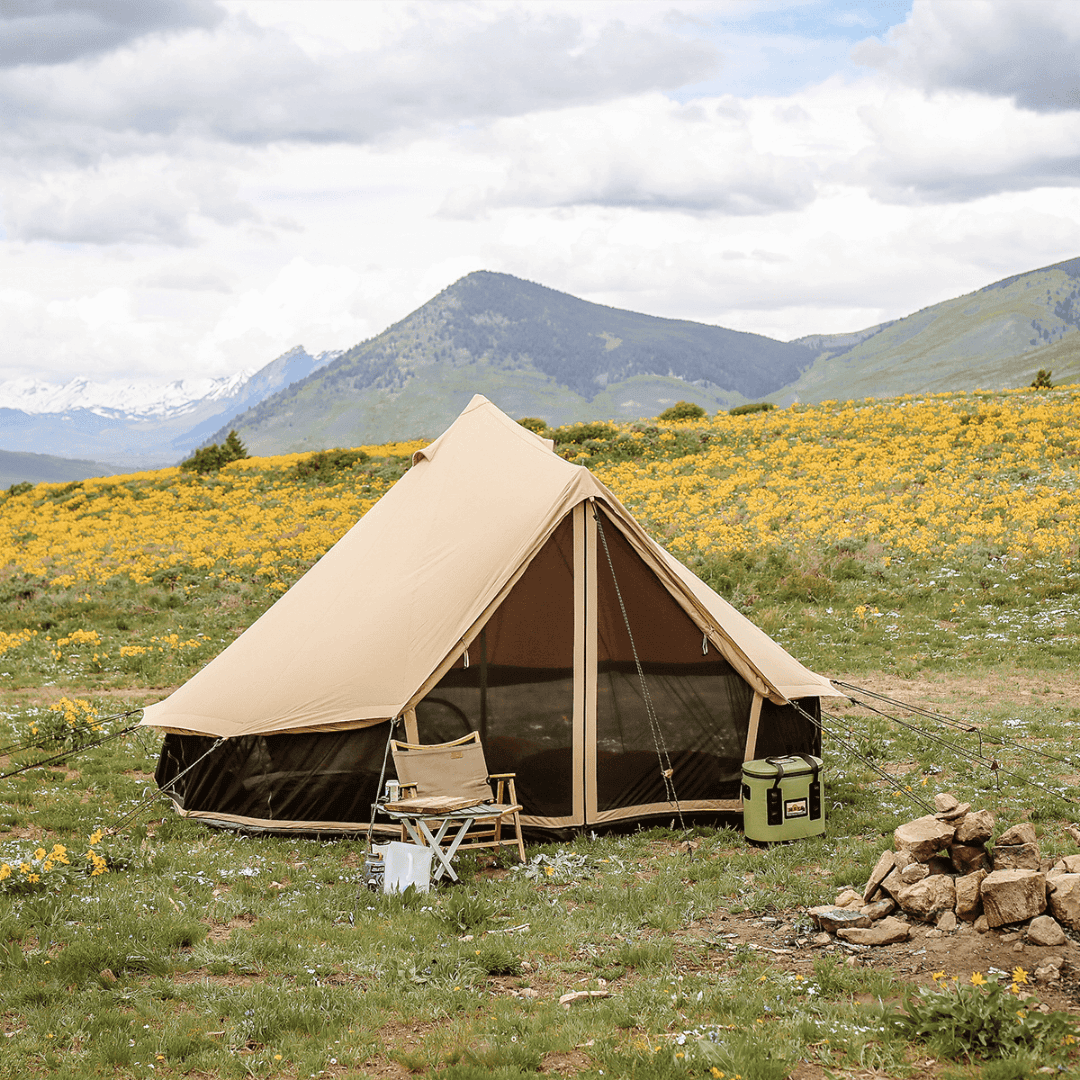 White Duck Outdoors Regatta Double Wall Bell Tent in grasy area with flowers and chairs