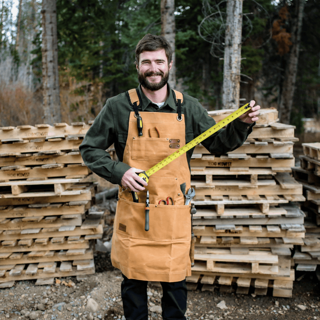 White Duck Outdoors Tan Work Apron with man holding measuring tape