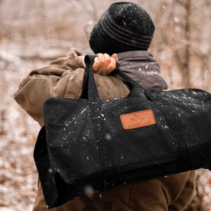 White Duck Outdoors Tote Canvas Log Carrier Bag black with man carrying it over his shoulder