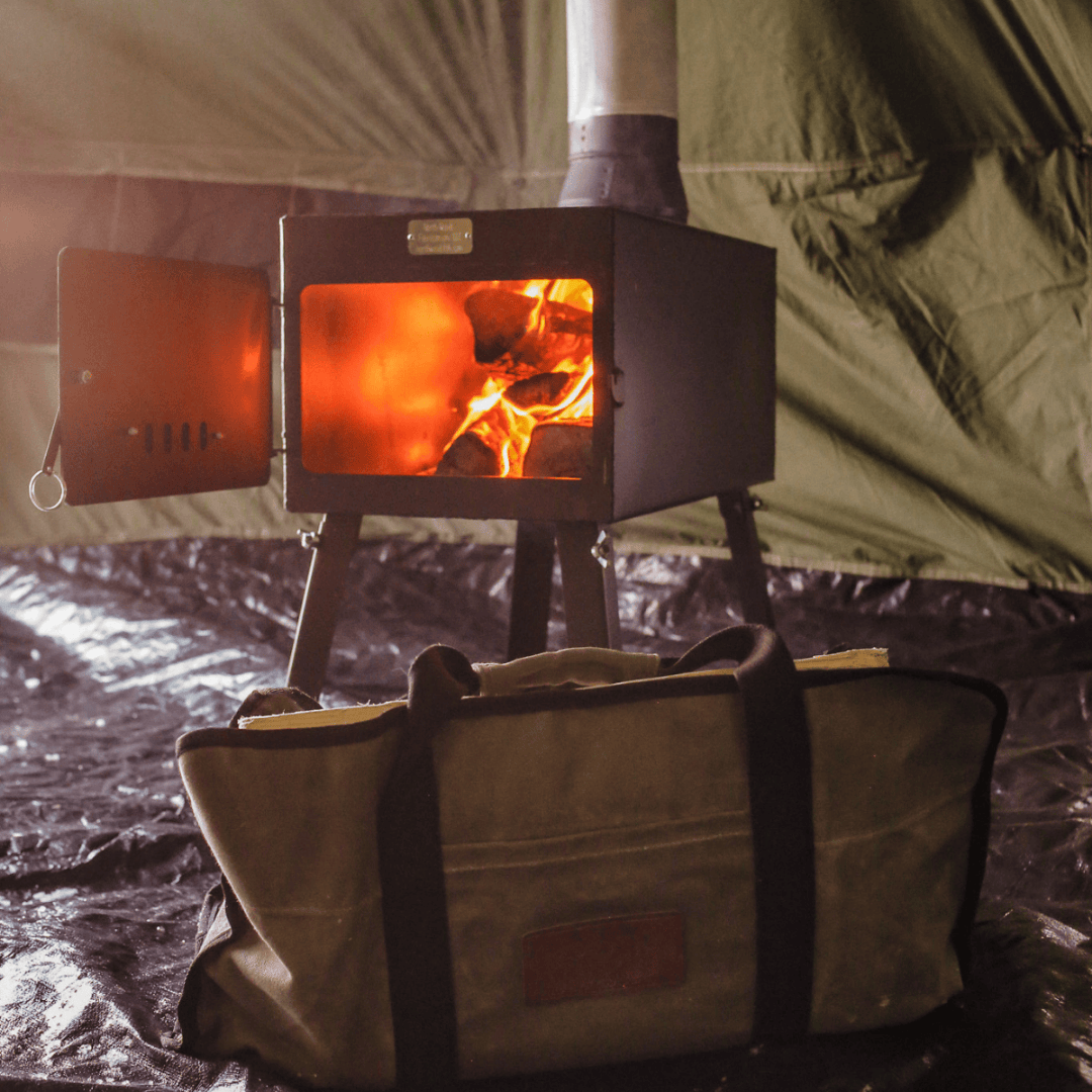 White Duck Outdoors Woodsman Wood Stove Kit opened and burning with close up of log carrier bag
