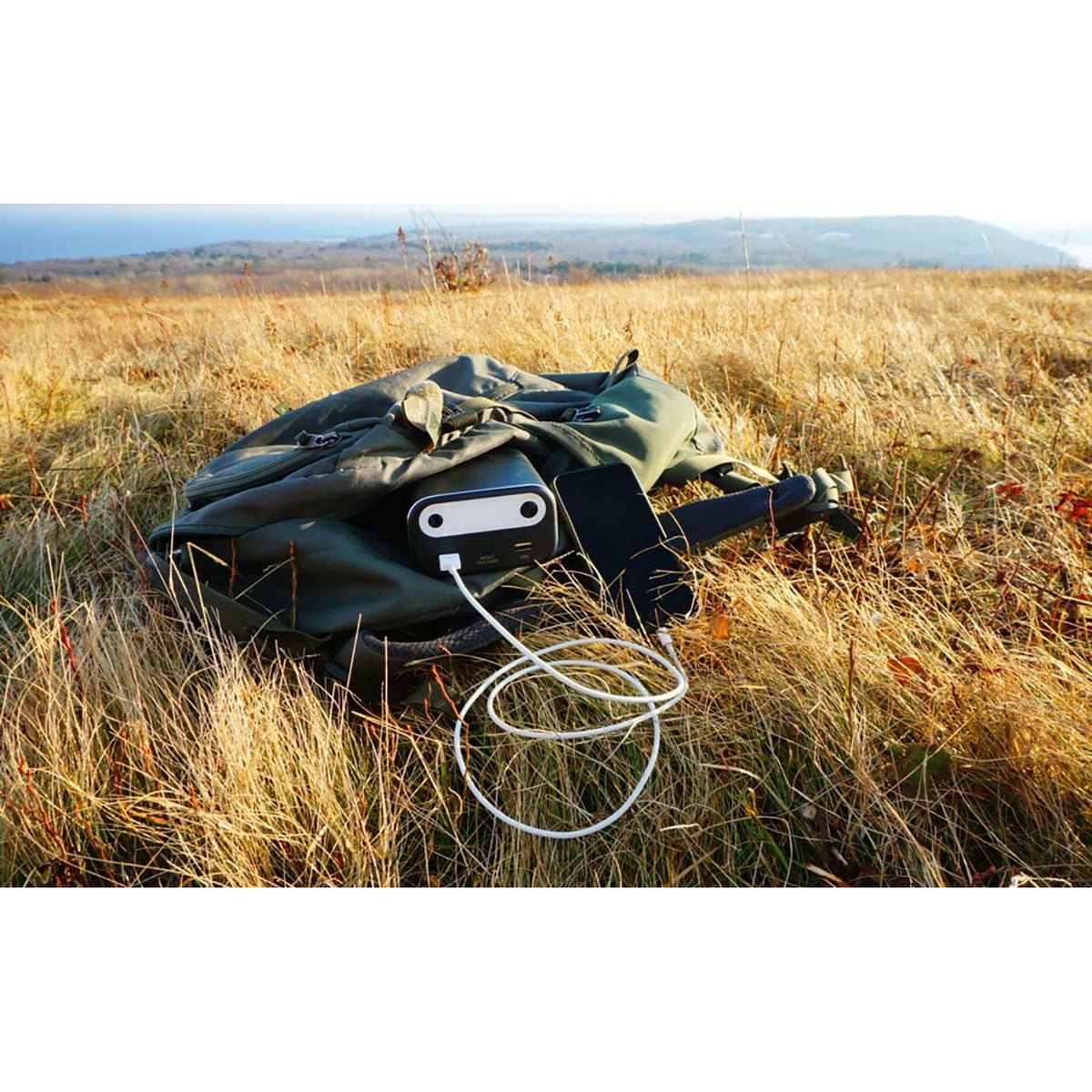 Photo of the Bluetti - AC10 99Wh/26756mAh Portable Power Station inside a bag in a field.