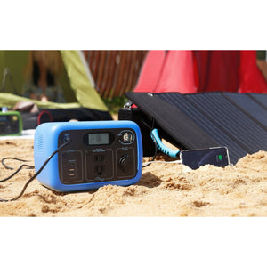 Photo of Bluetti - AC30 300Wh/300W Portable Power Station in color blue charged in a solar panel placed in a sand.