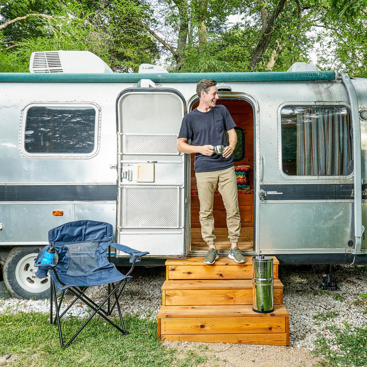 Picture of a Man with a Travel Berkey® System (1.5 gal) on the wooden stairs of his RV. - Water Filtration