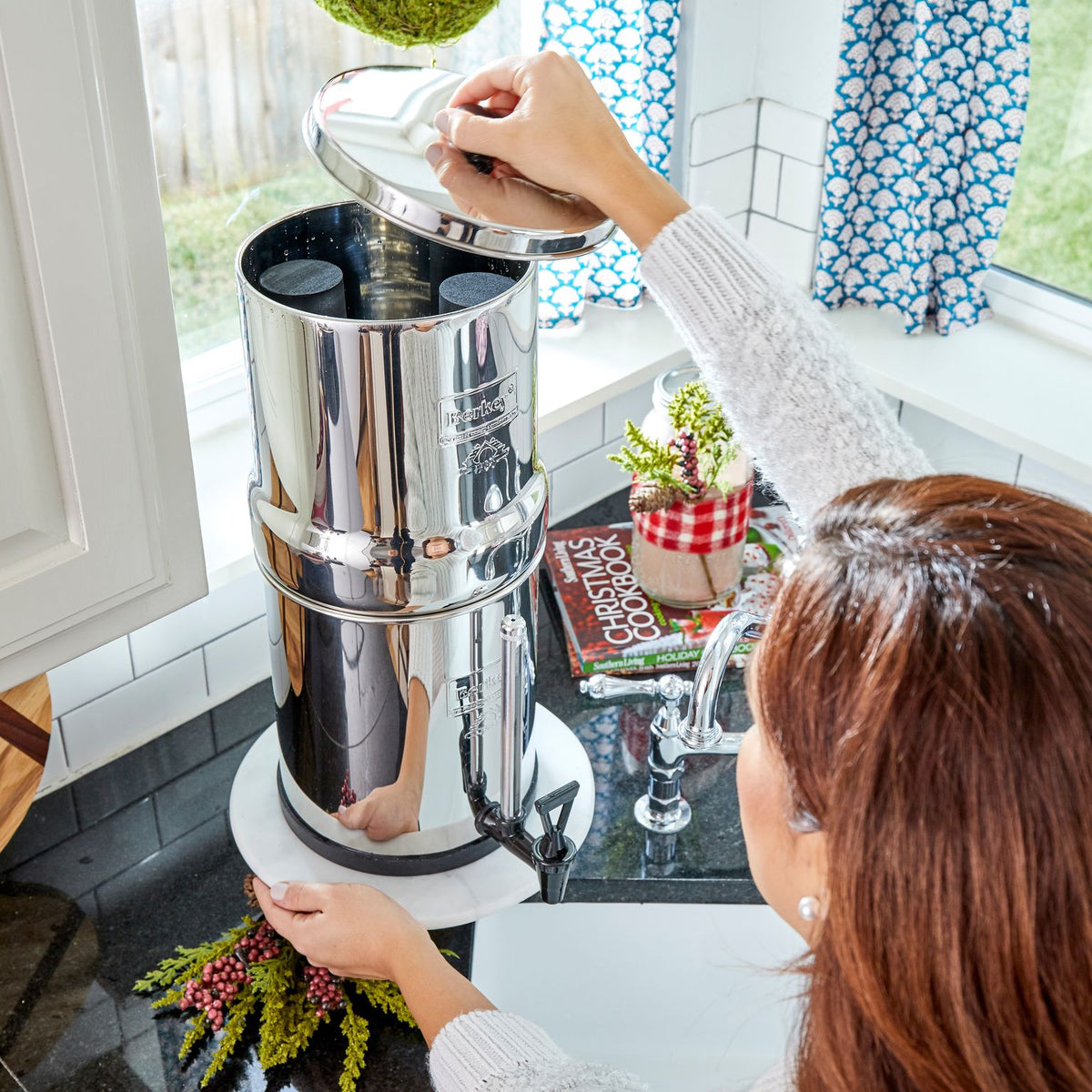 Picture of  Woman opening the top chamber of ROYAL BERKEY® Water Filter 3.25 GALLONS. - Water Filtration